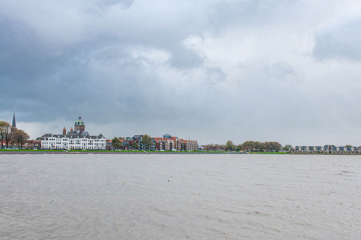 Uitzicht op Hoorn met op de voorgrond het IJsselmeer, het is bewolkt.