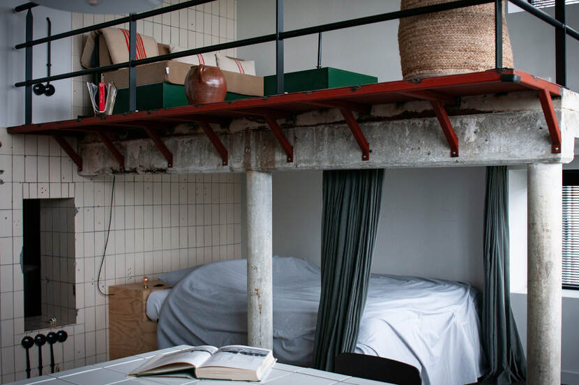 Het interieur van een appartement in de Suvelfabryk, een bed in een oude, industriële fabriekshal.
