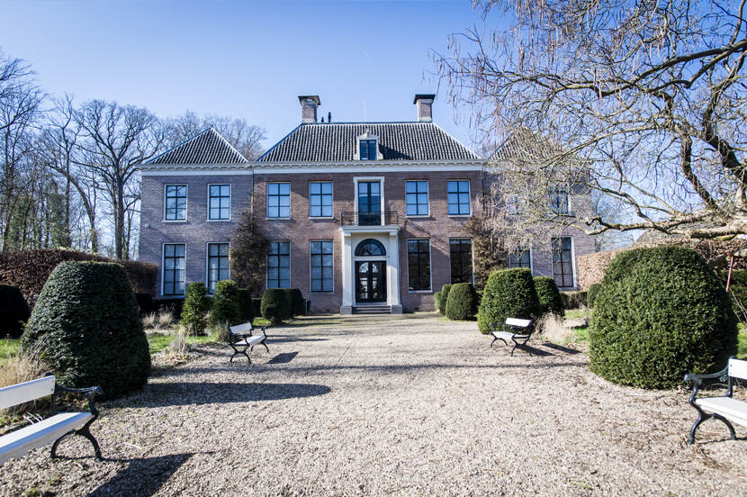 Het landhuis van landgoed Boom en Bosch, een symmetrisch huis met daarvoor een pad en een tuin